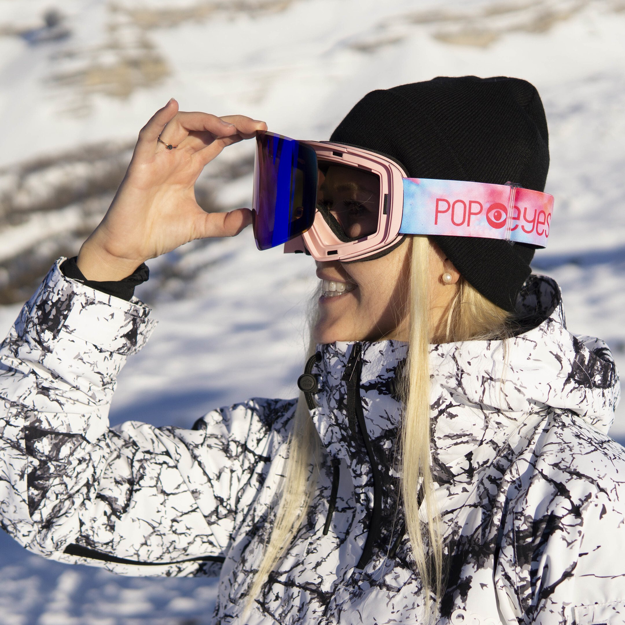 Athletin zeigt die Wechselscheibe der Skibrille JAMIE Baby Pink, blaue Scheibe, rosa Design-Band, ideal für Damen.
